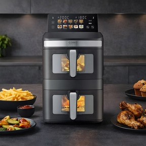 A modern black double-chamber air fryer on a kitchen counter, displaying food icons on its screen.