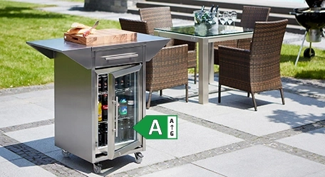 Kühlschrank mit Getränken und Grill im Garten mit Tisch und Stühlen