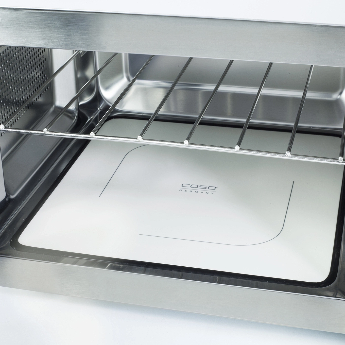 Close-up of an oven with a rack and a white plate with a logo
