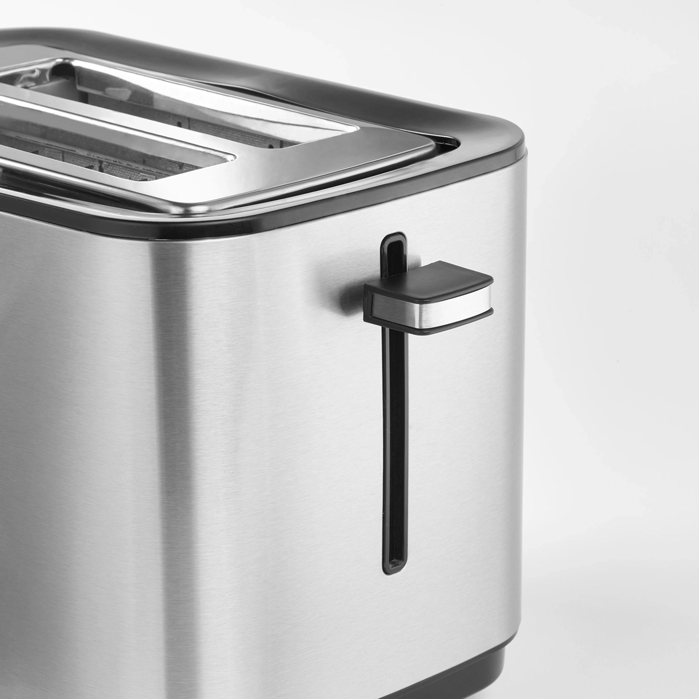 Nahaufnahme eines Toasters aus Edelstahl mit schwarzem Griff und Schlitz