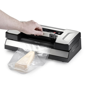 A person operates a vacuum sealer packaging cheese for preservation.