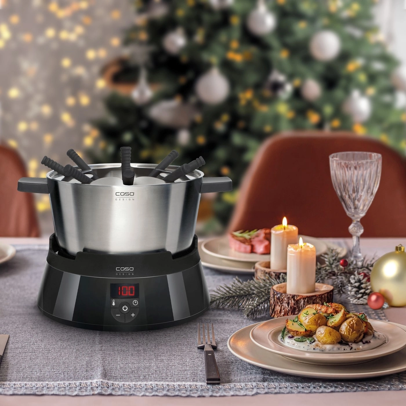 Ein Fondue-Set mit einem Weihnachtsbaum im Hintergrund, bereit für ein Festessen.