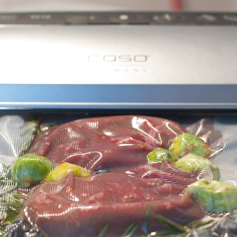 Meat and vegetables in vacuum packaging. Caso device in the background.
