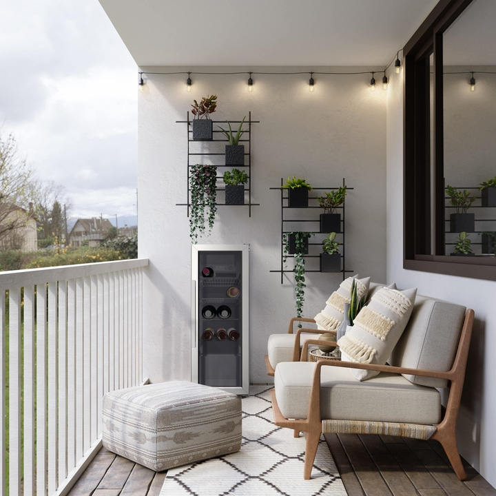 Balkon mit Pflanzen, Sitzgelegenheiten, Wein und Lichterketten. Gemütliche Atmosphäre.