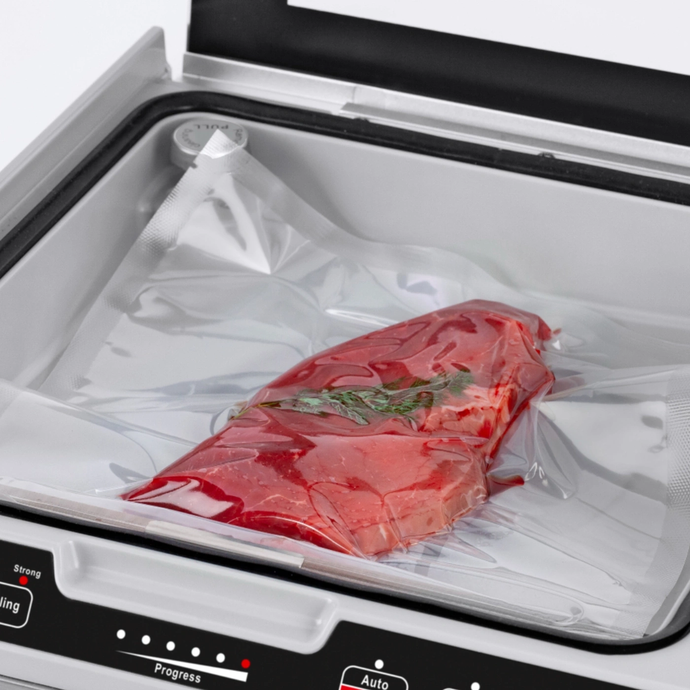 Meat in vacuum sealer, packaged for preservation, red meat, fresh herbs, food storage