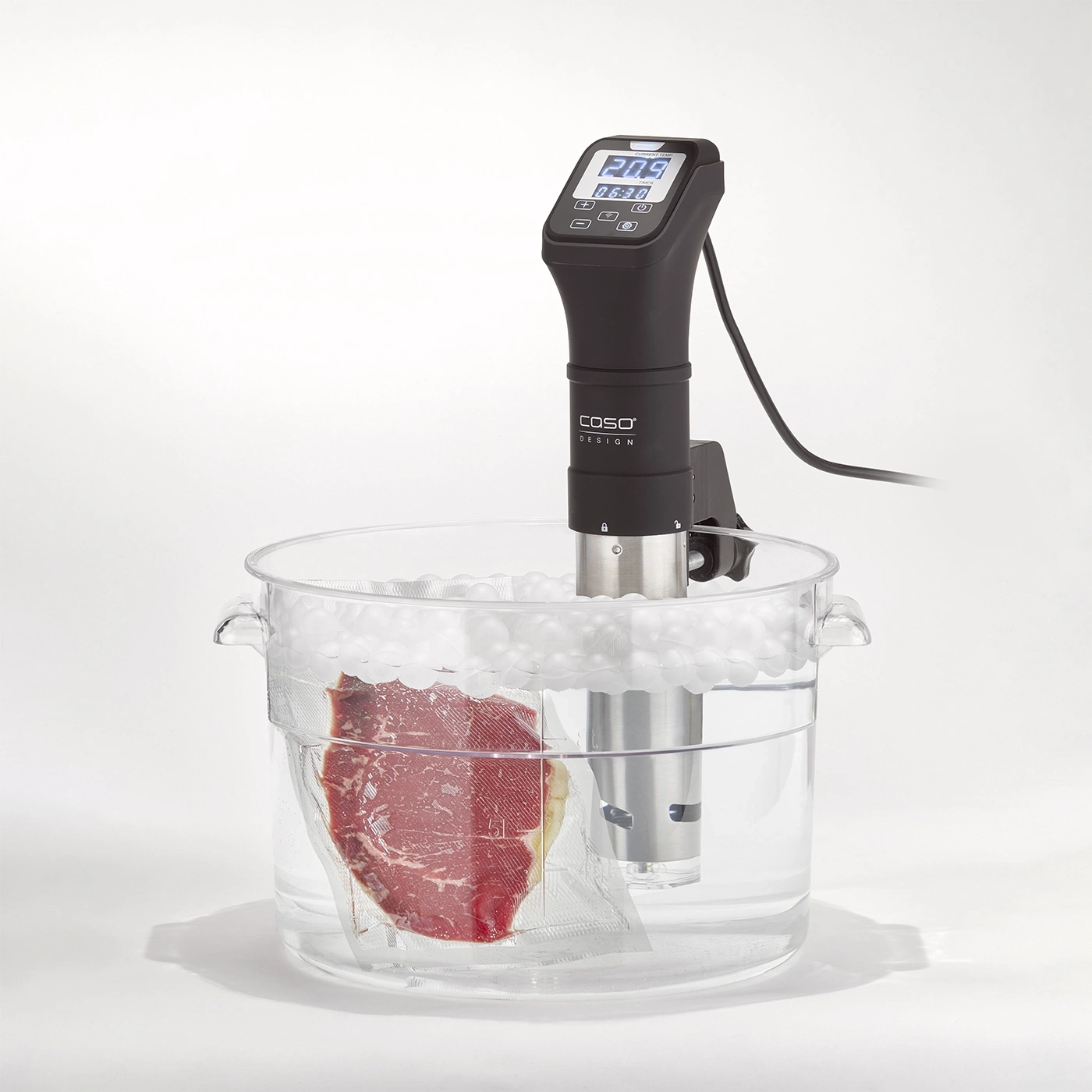 Sous vide machine with meat in water bath. Temperature display and time.
