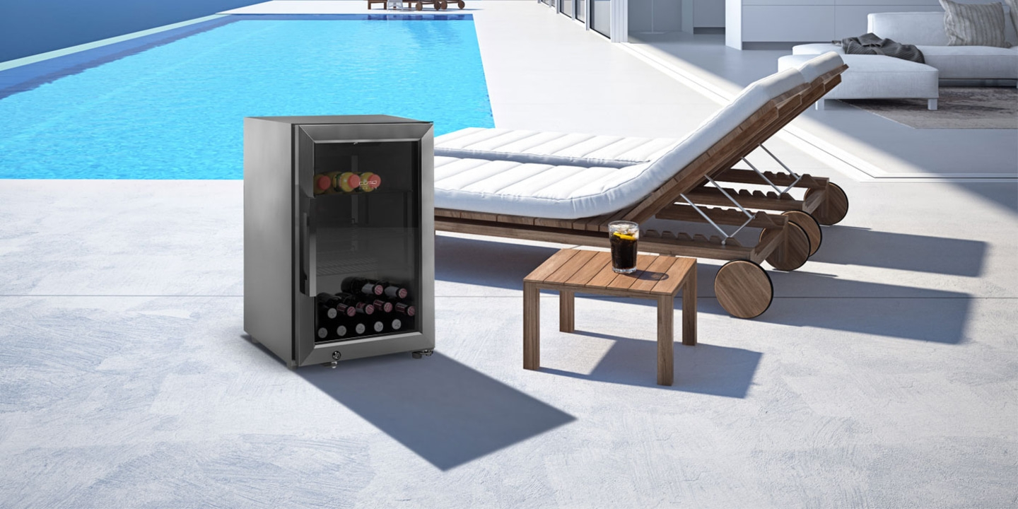 Refrigerator by pool with drinks and a lounge chair