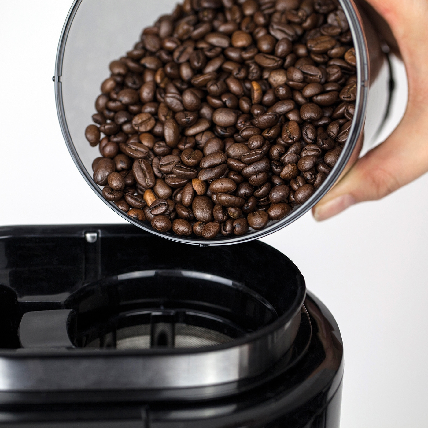 Kaffeebohnen werden in eine Kaffeemaschine gefüllt, Nahaufnahme, Kaffeezubereitung