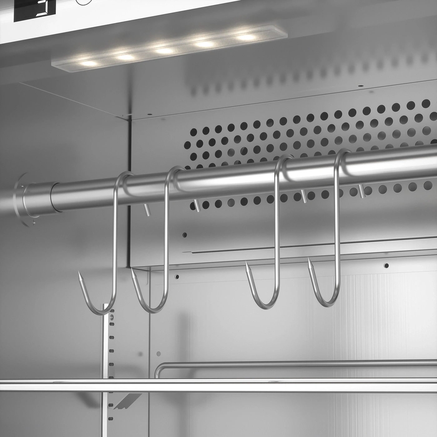 Meat hooks in a stainless steel refrigerator with lighting and ventilation holes.