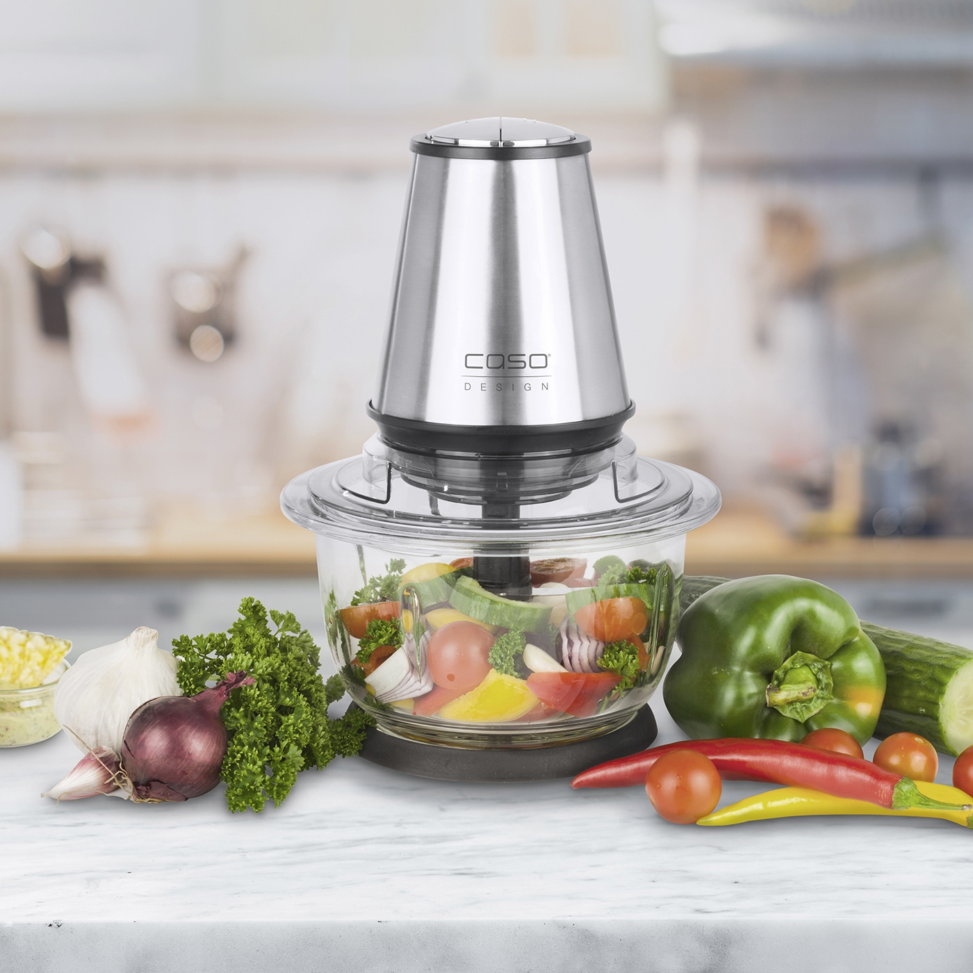 Food processor with vegetables on marble, close-up shot, kitchen appliance.