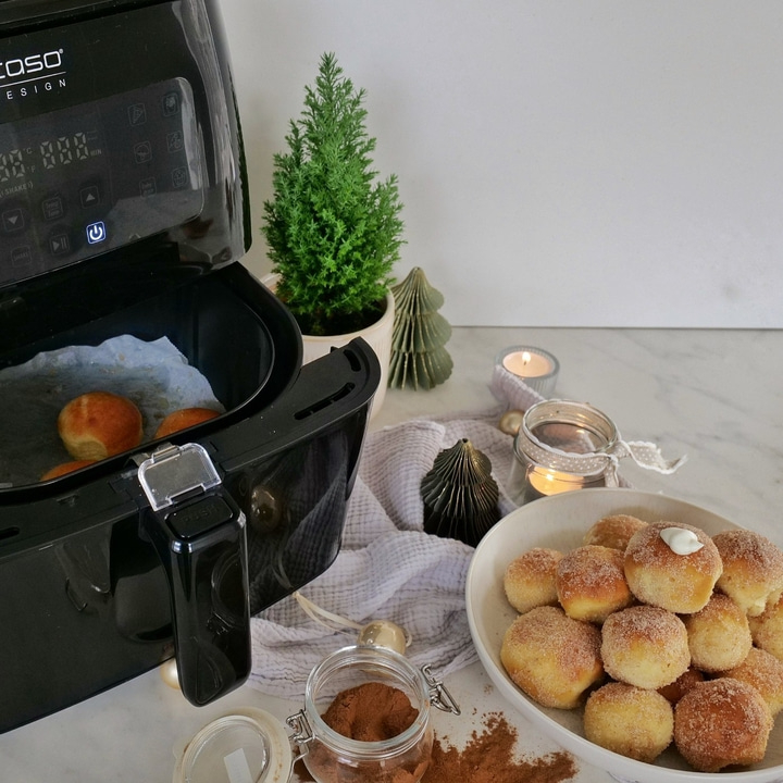 Air fryer with pastries, cinnamon, and decorations on a table