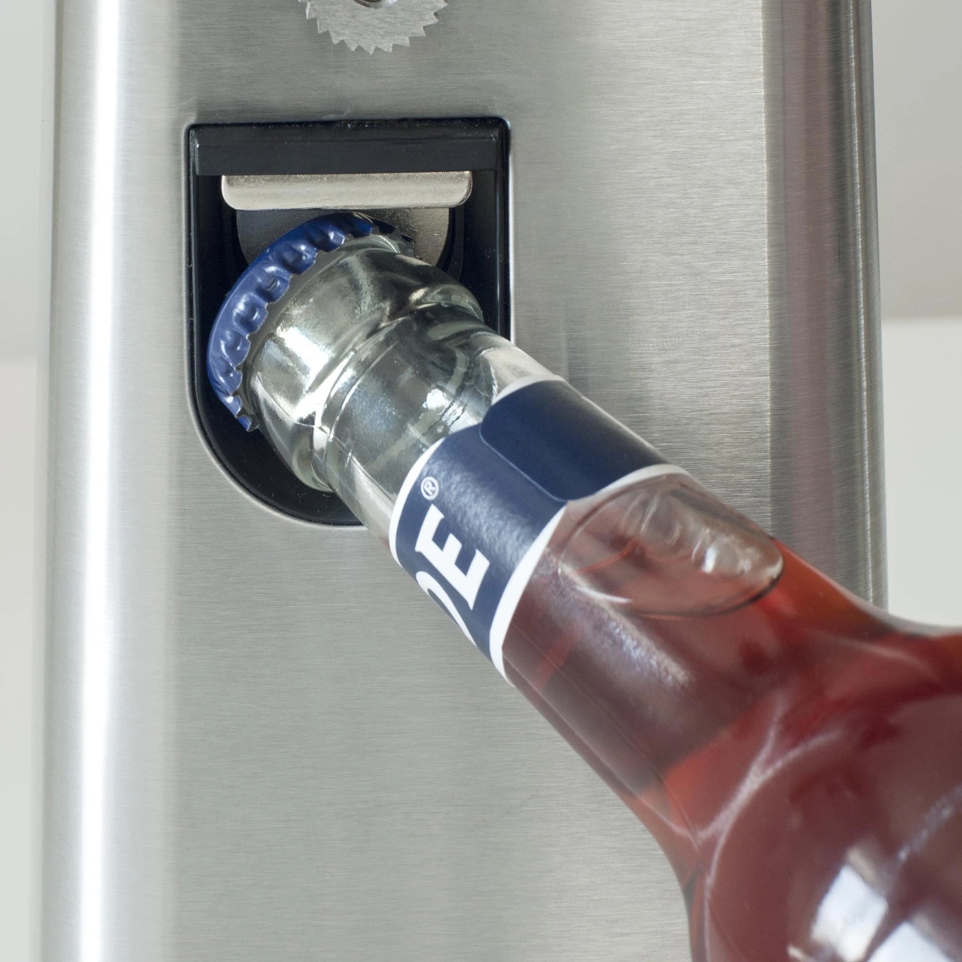 Eine Flasche wird mit einem Flaschenöffner geöffnet, Nahaufnahme.