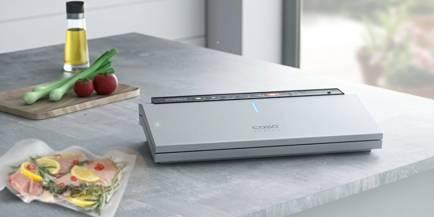 A vacuum sealer on a countertop with ingredients.