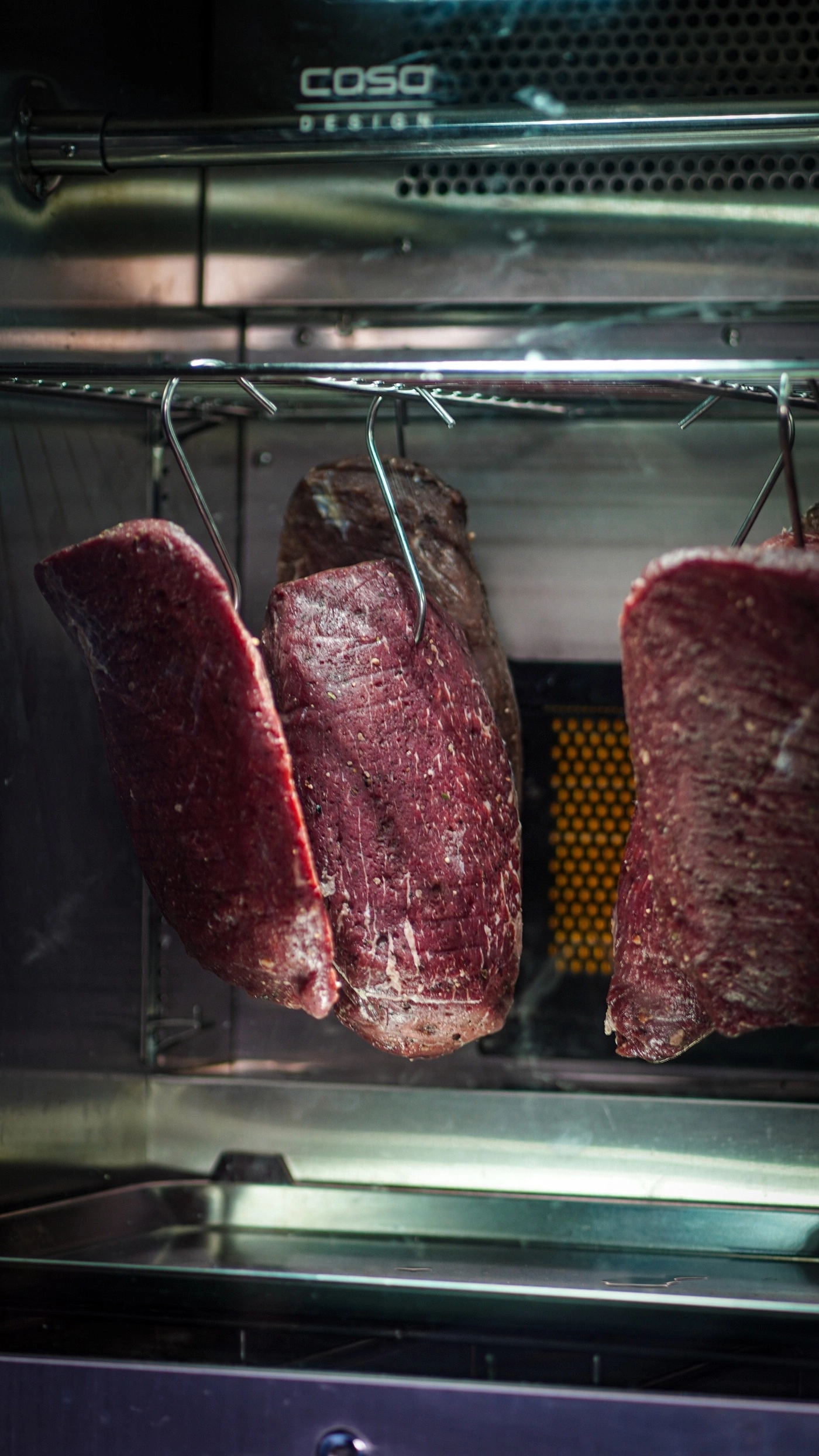 Raw meat hanging in an oven for aging.