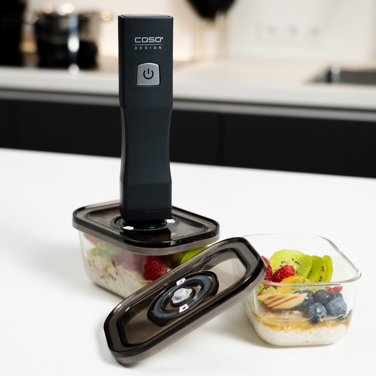Vacuum sealer with containers of fruit and cereal on a white table