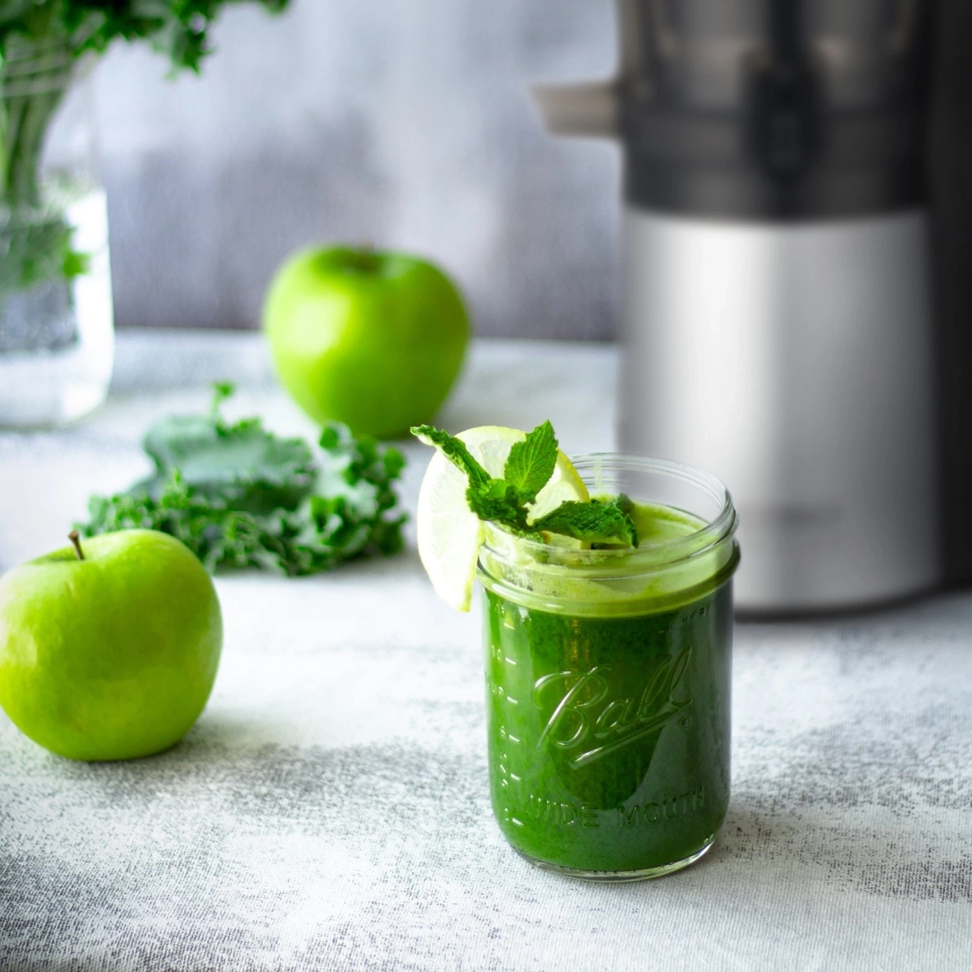 Grüner Smoothie mit Äpfeln, Minze und Zitrone in einem Glas. Gesundes Getränk.