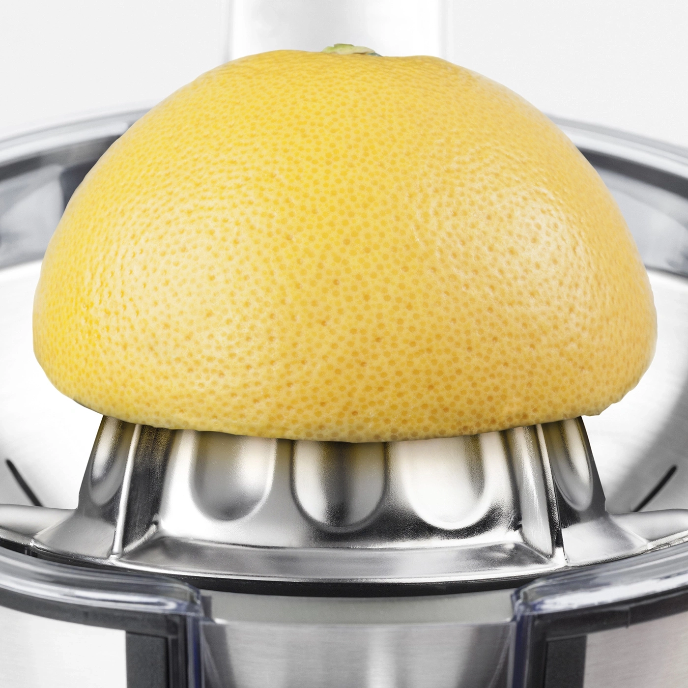 Grapefruit auf einer Zitruspresse. Gelbe Frucht, silberne Presse, Nahaufnahme, hell