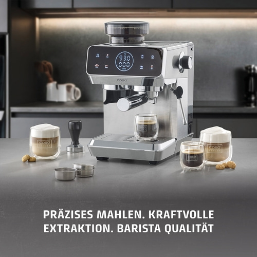 Eine silberne Kaffeemaschine mit zwei Gläsern Kaffee und Keksen.