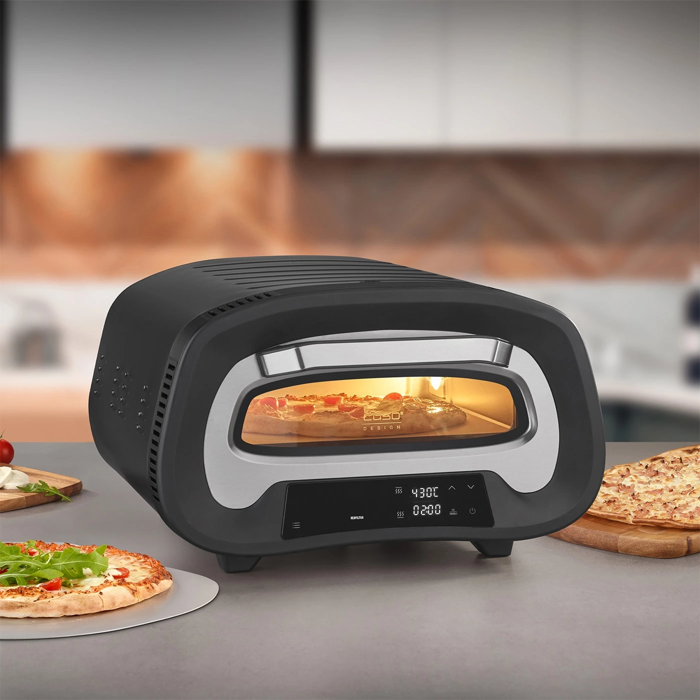 Pizzaofen mit Pizza und Zutaten auf einem Tisch, bereit zum Servieren.