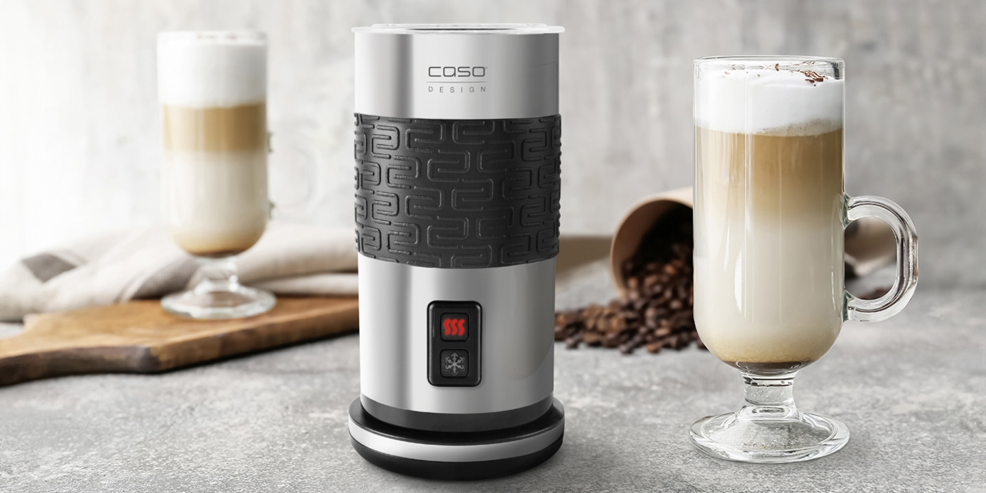 Milchaufschäumer mit Latte Macchiato und Kaffeebohnen auf grauem Hintergrund