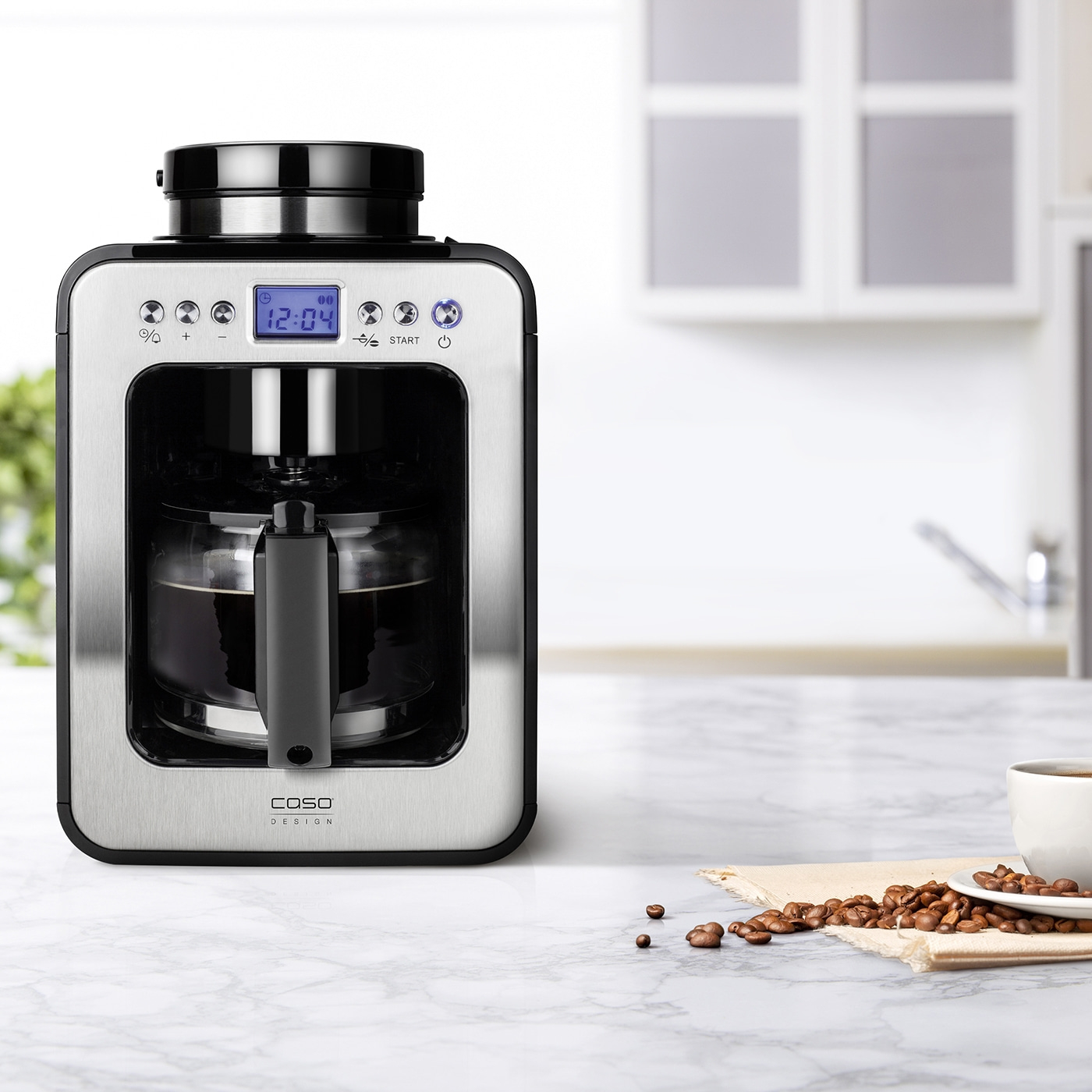 Kaffeemaschine mit Uhr, Kaffeebohnen und Tasse auf Marmortisch in der Küche