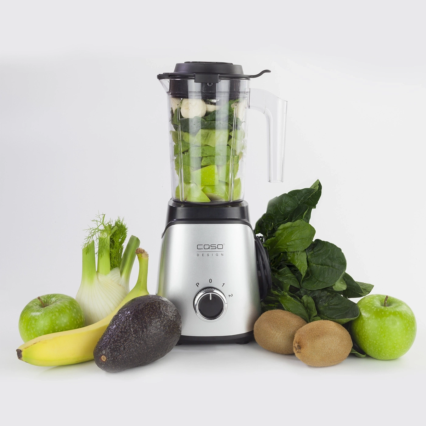 Ein Mixer mit Zutaten wie Äpfeln, Bananen, Kiwi und Spinat.