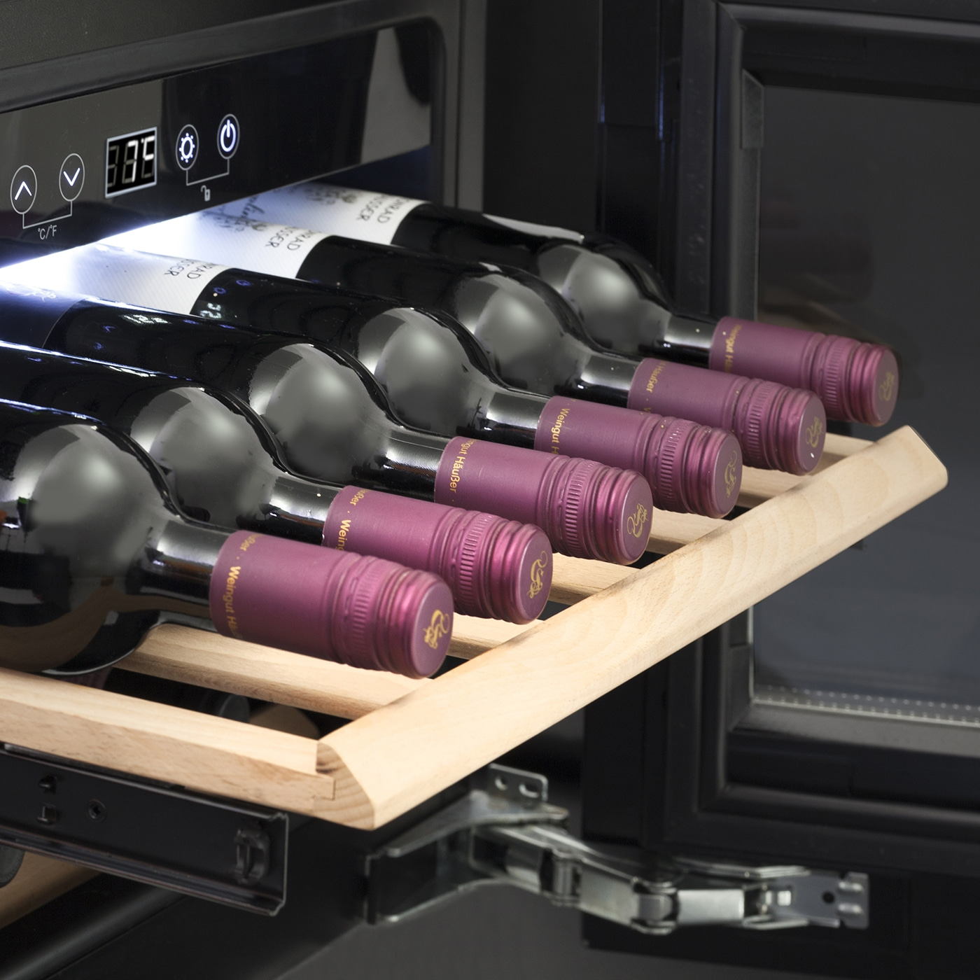 Wine cooler with wine bottles on a wooden shelf, temperature display.