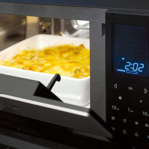 Microwave with food cooking, digital display showing time 2:02, and buttons