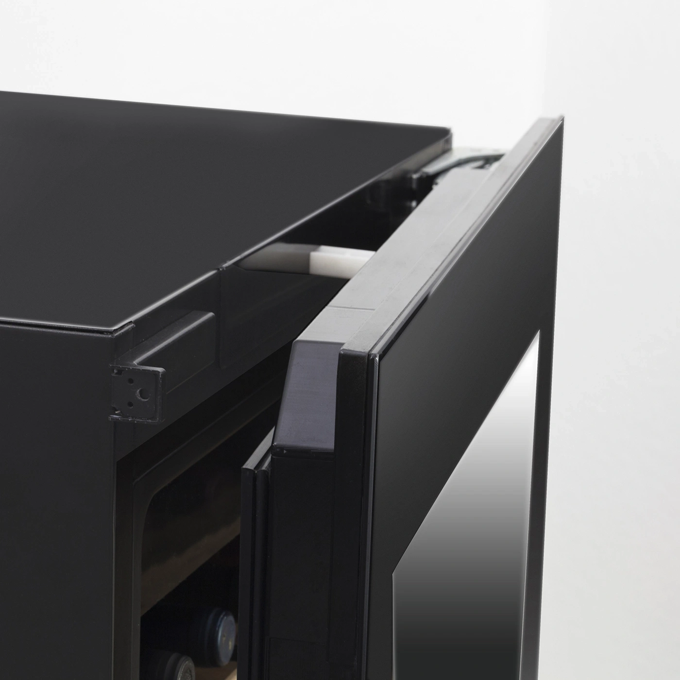 Black refrigerator with open door, detail shot, interior view, wine bottles inside