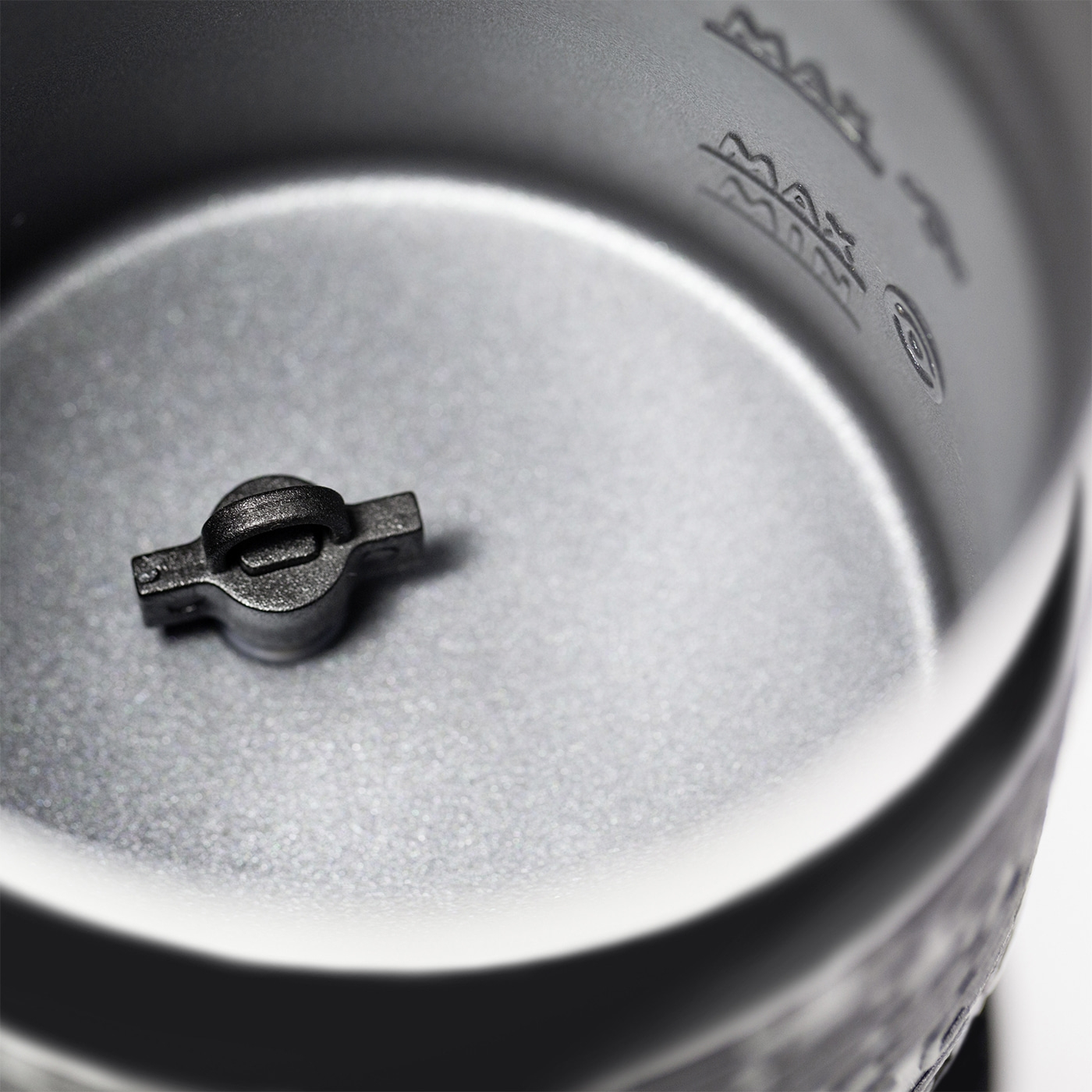 Close-up of a metallic object with markings and a small handle