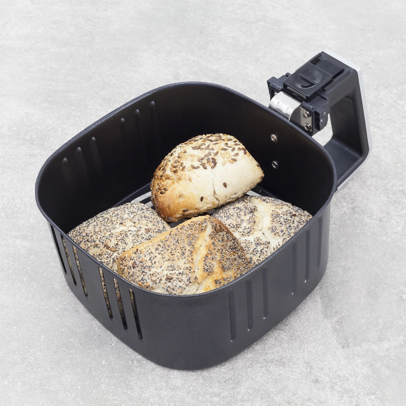 Air fryer with bread. Black basket with bread on a gray background.