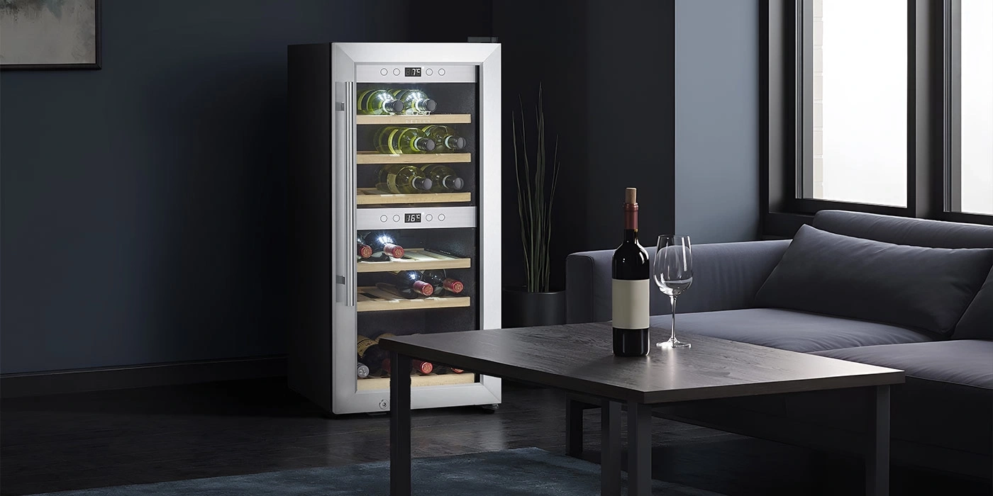 A modern wine cooler with bottles and glasses on a table.