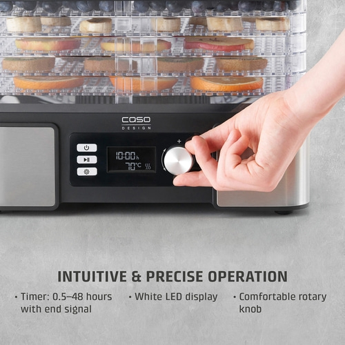 Food dehydrator with control panel, fruits and vegetables on trays, hand turning knob