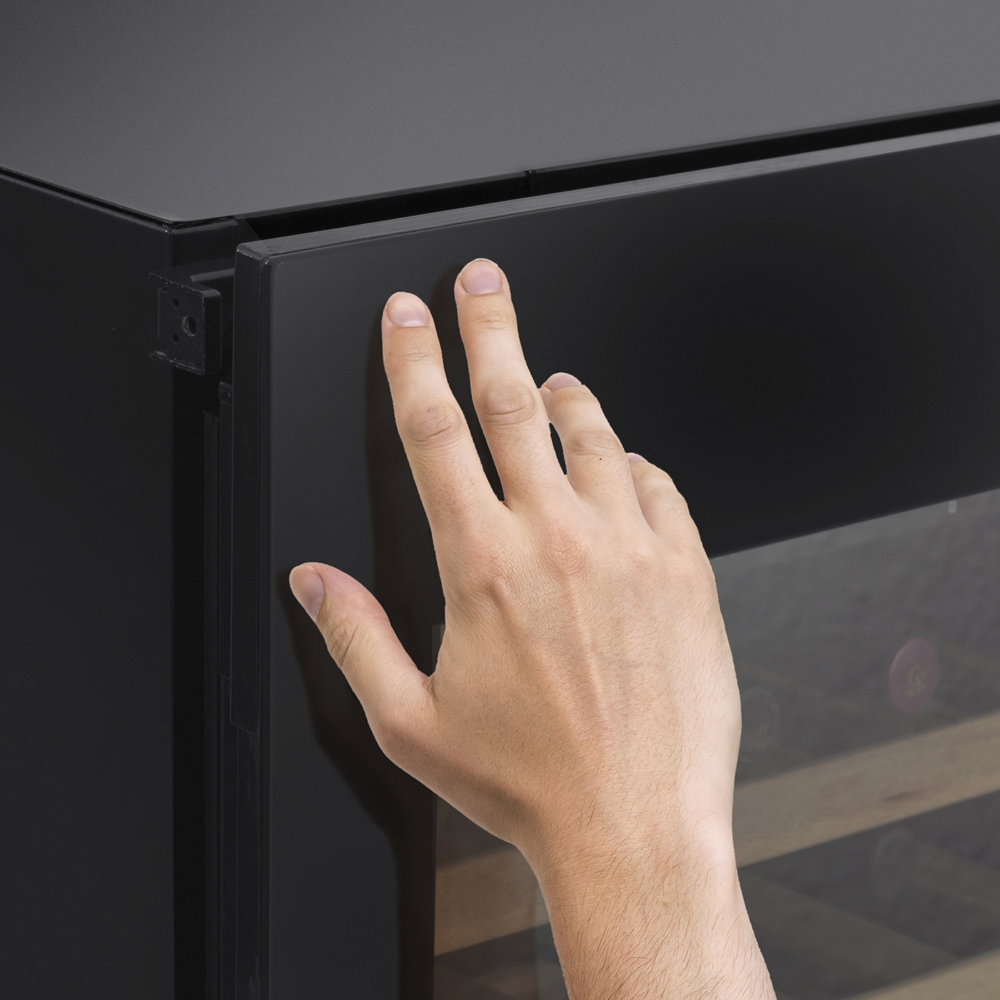 Hand touching black door. Fingers on surface. Close-up shot.