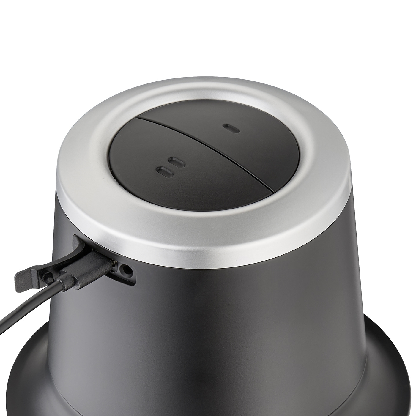Black speaker with silver rim and USB cable, close-up, buttons on top