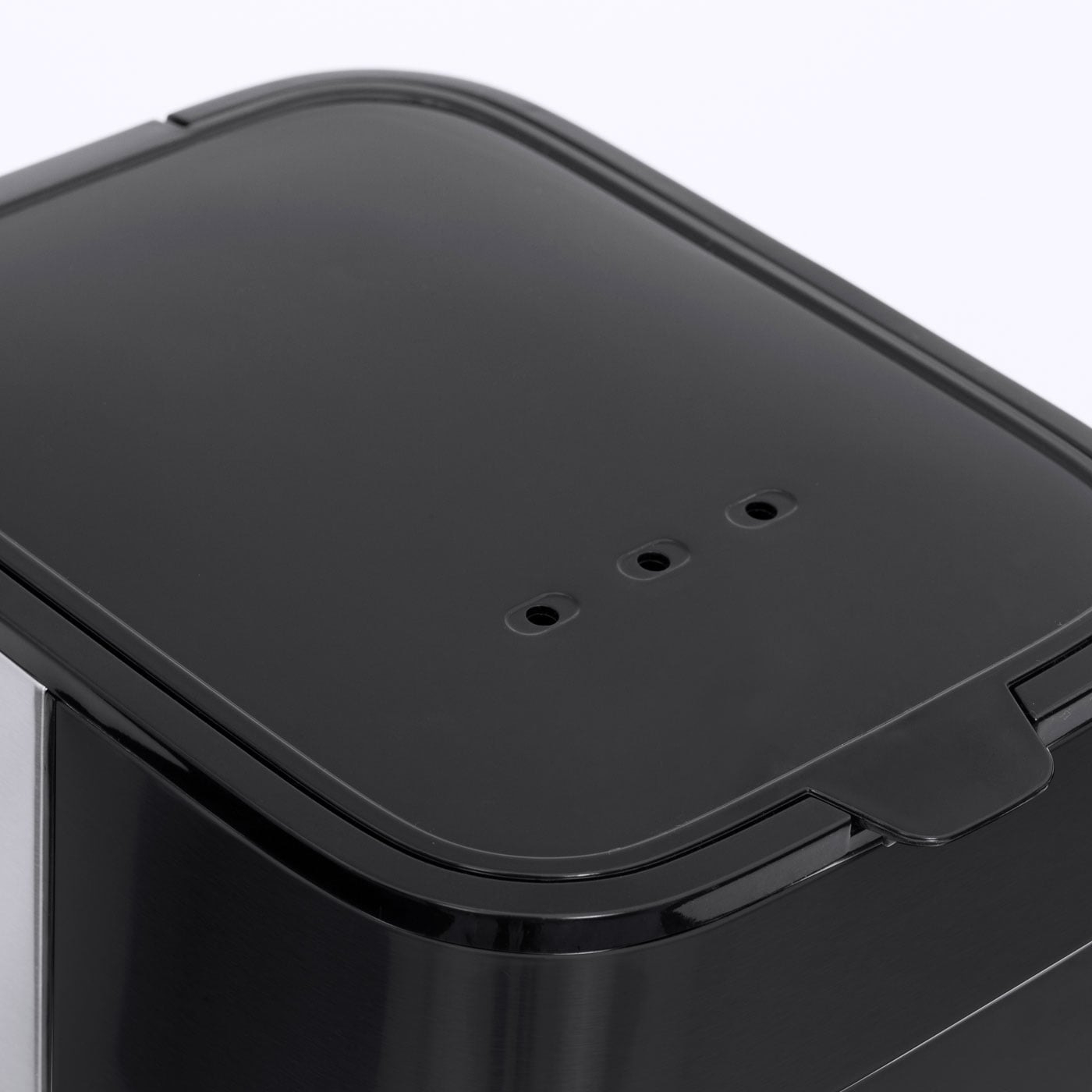 Black lid with holes and handle, close-up, detail shot, shiny surface