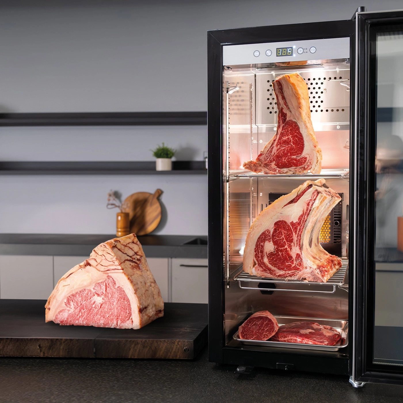 Ein offener Kühlschrank mit Fleischstücken, ein Stück Fleisch auf einem Brett.