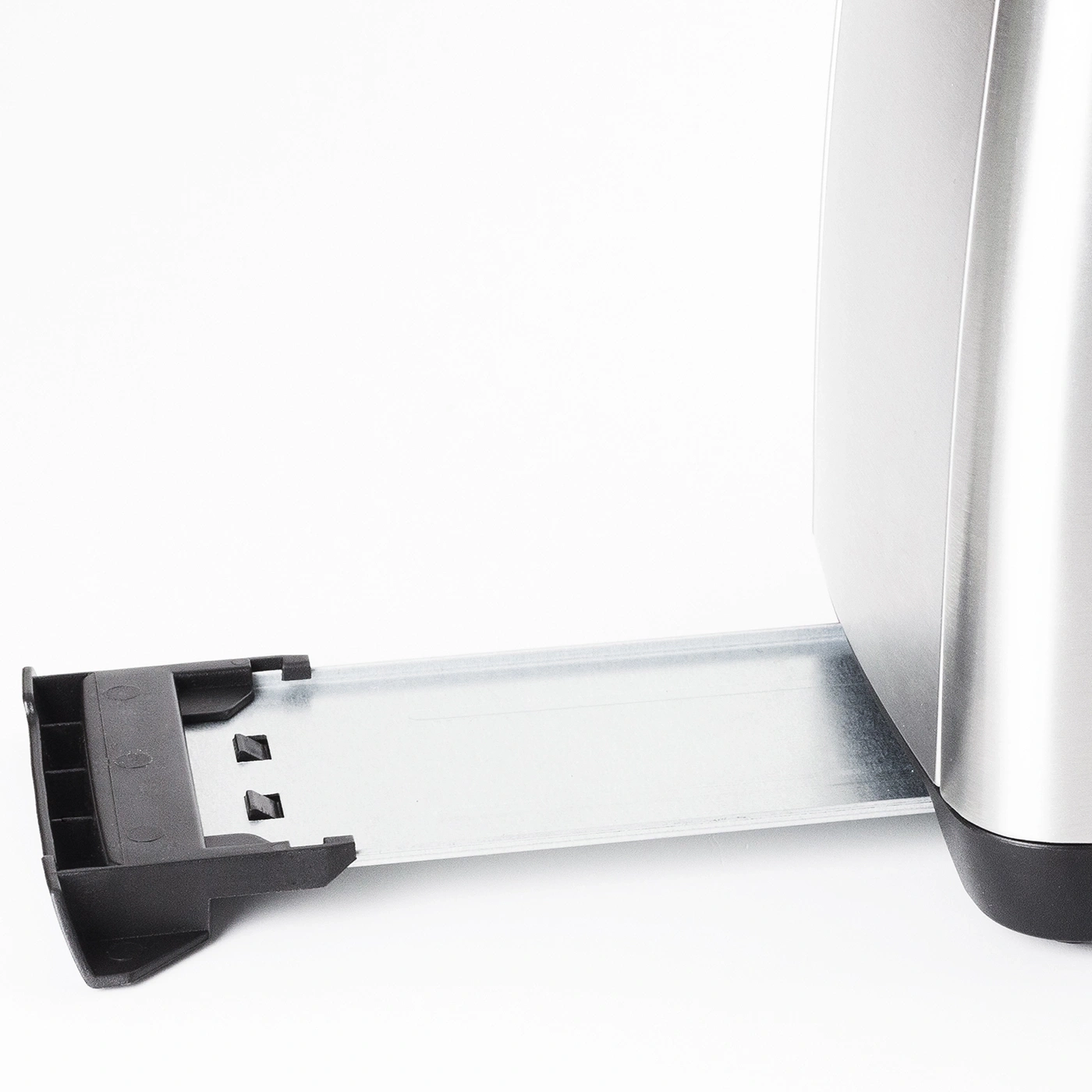 Nahaufnahme eines Toasters mit herausgezogener Krümelschublade und weißem Hintergrund