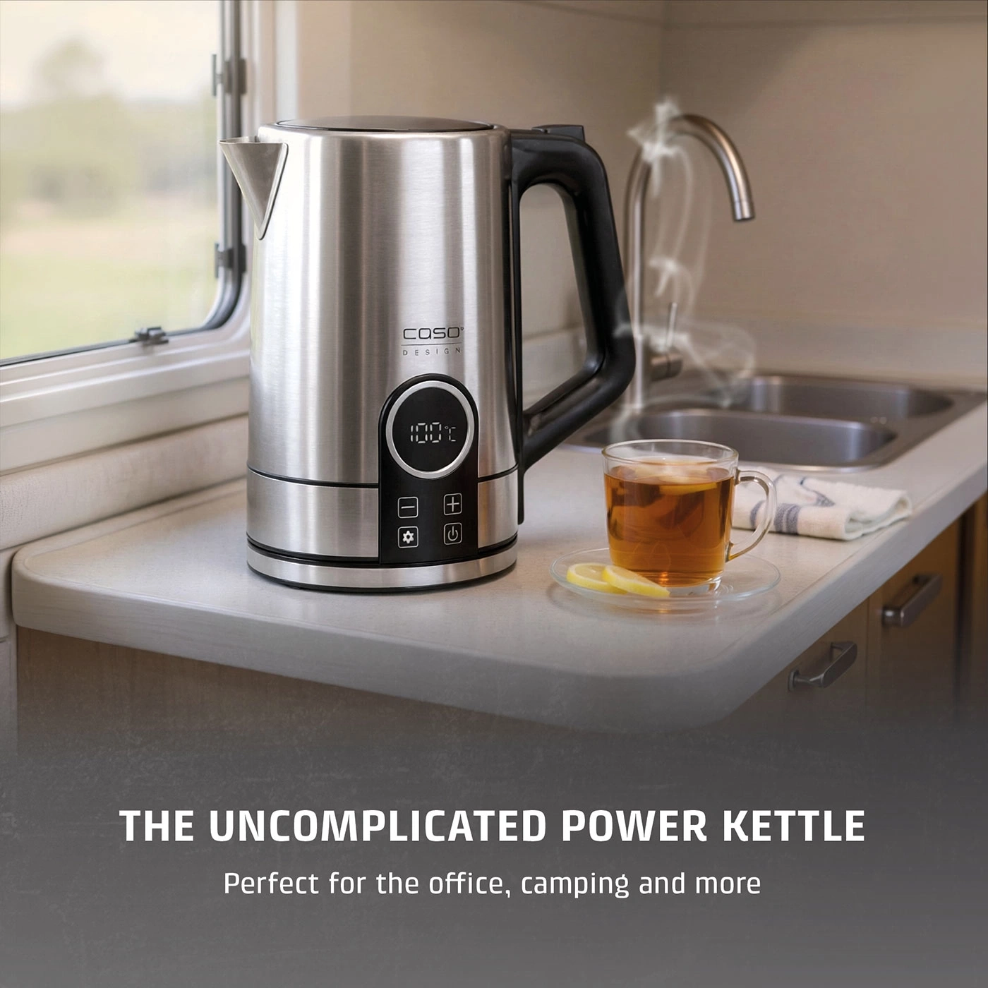 A stainless steel kettle with a temperature display at 100 degrees Celsius next to a cup of tea.