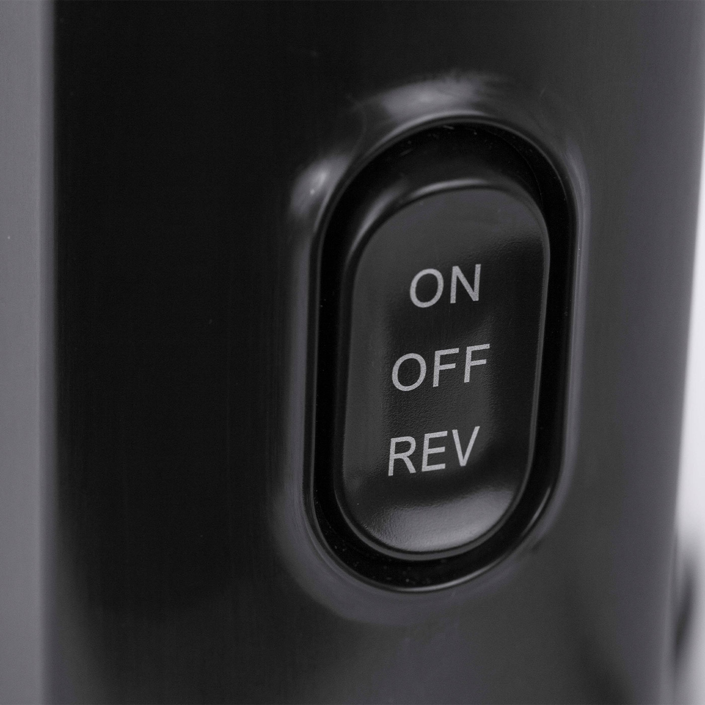 Black button with options 'ON', 'OFF', and 'REV' on a device.