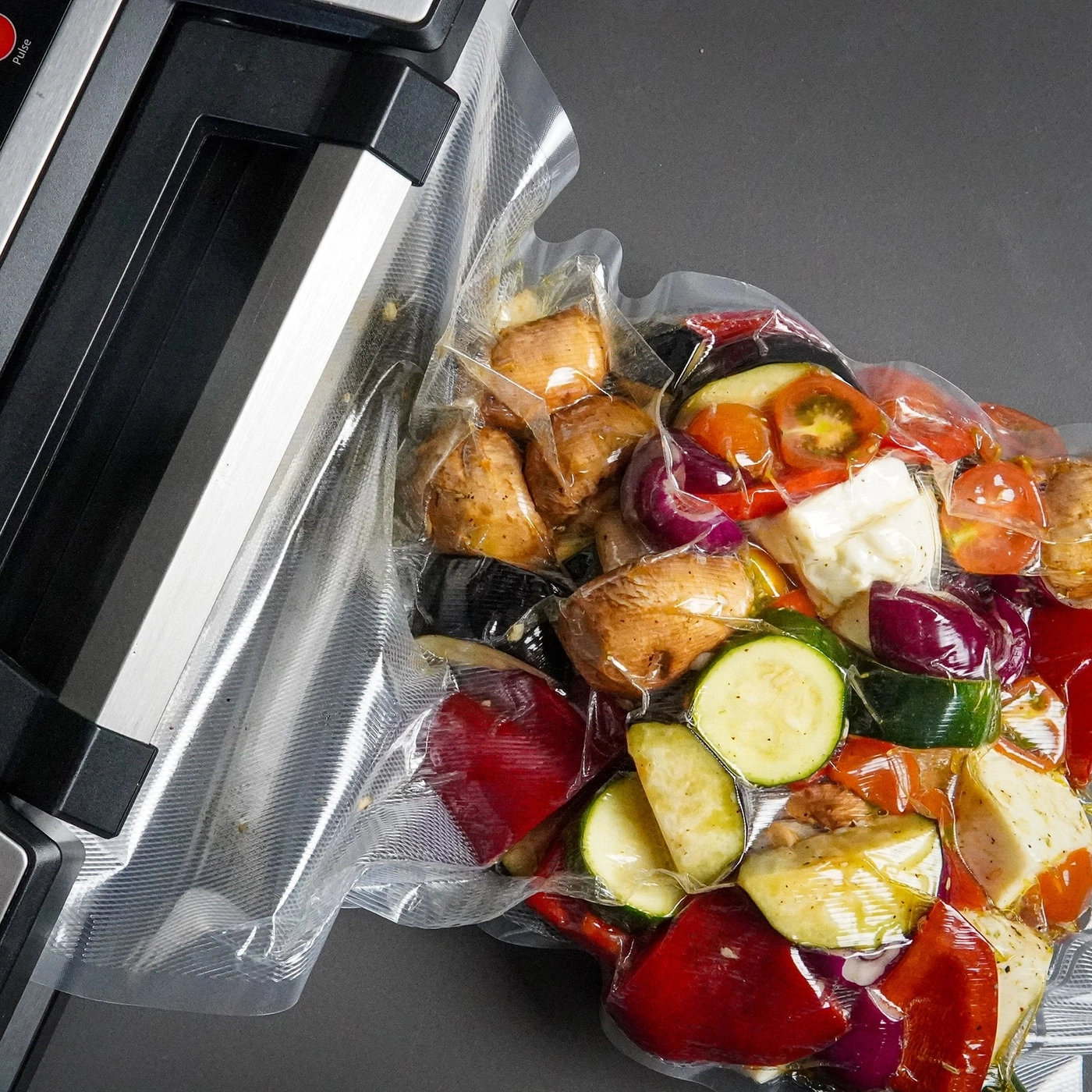Vakuumverpacktes Fleisch mit Kräutern und Gewürzen auf schwarzem Untergrund.