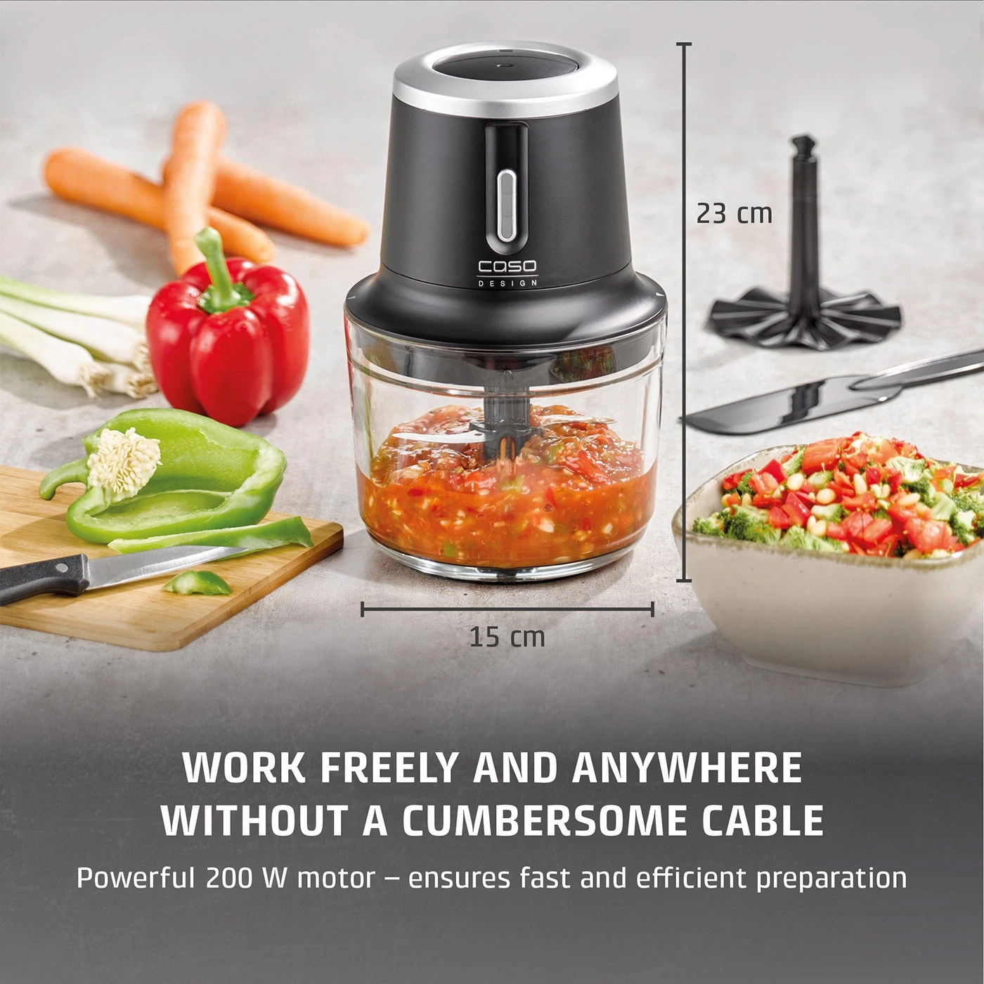 A cordless food chopper with vegetables and a bowl of salad.