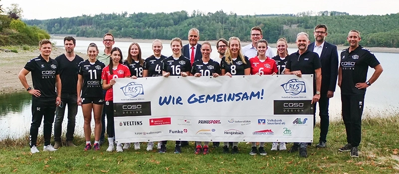 Gruppe von Menschen, die ein Banner mit der Aufschrift "WIR GEMEINSAM!" halten.