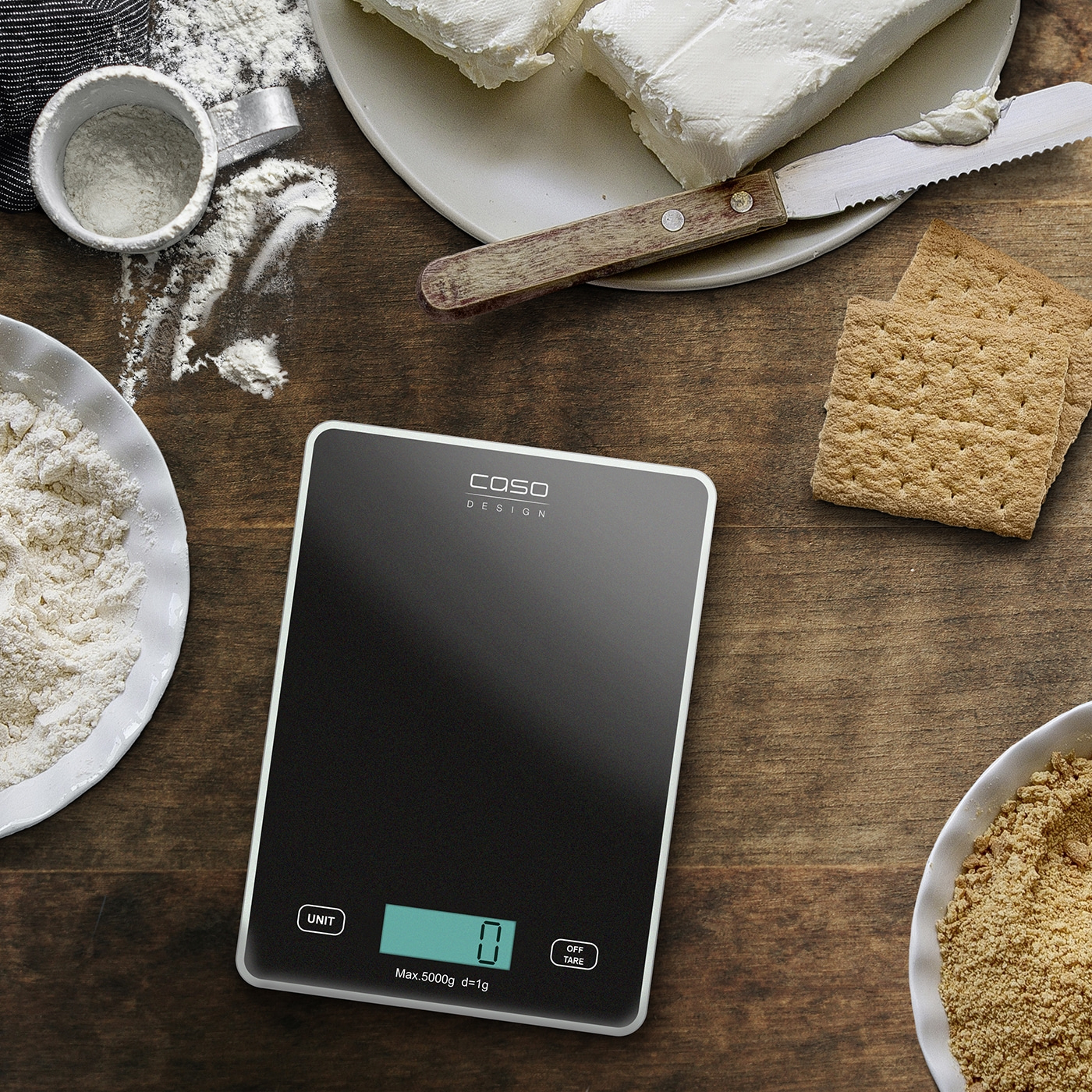 Kitchen scale with ingredients for a cake on a wooden table