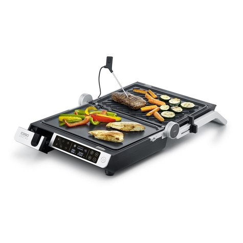 Electric grill with vegetables and meat, ready for cooking a meal.