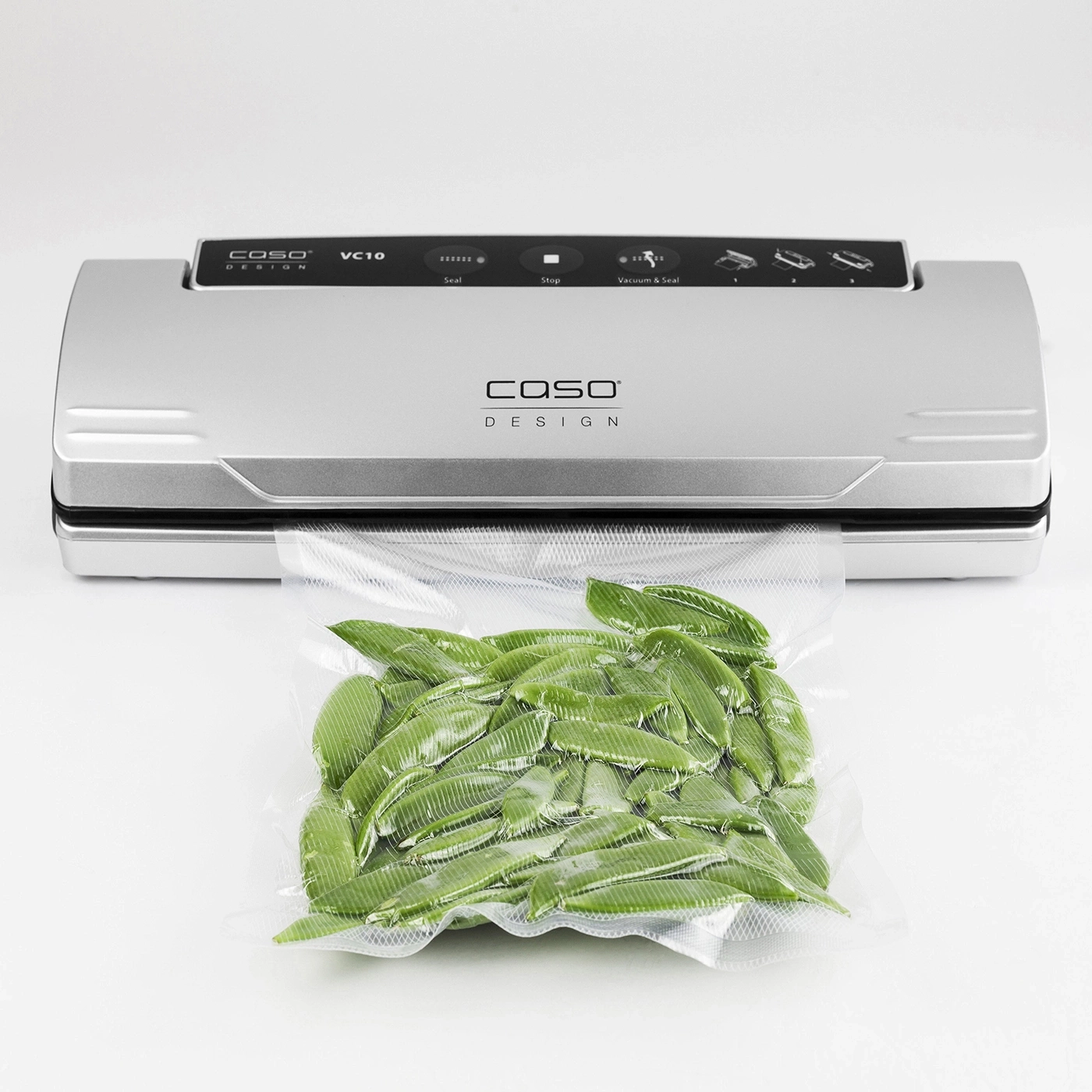 Vacuum sealer with bag filled with green leaves on a white background