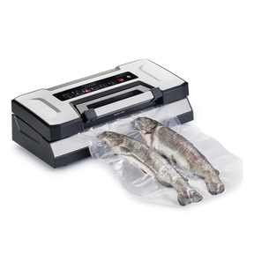 Vacuum sealer with two fish in a plastic bag, ready for vacuum sealing process.