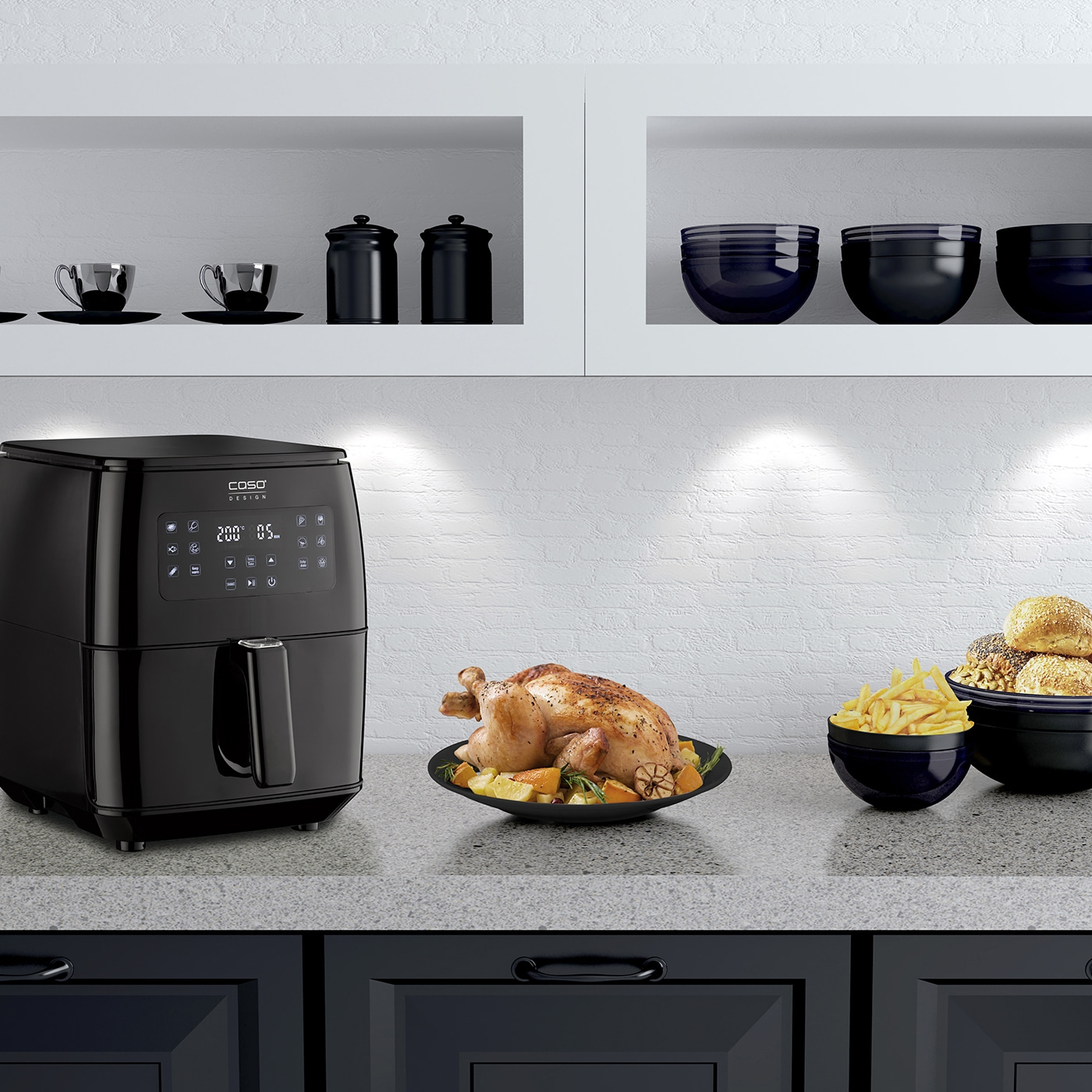 Black air fryer with chicken, fries, and rolls on the countertop.