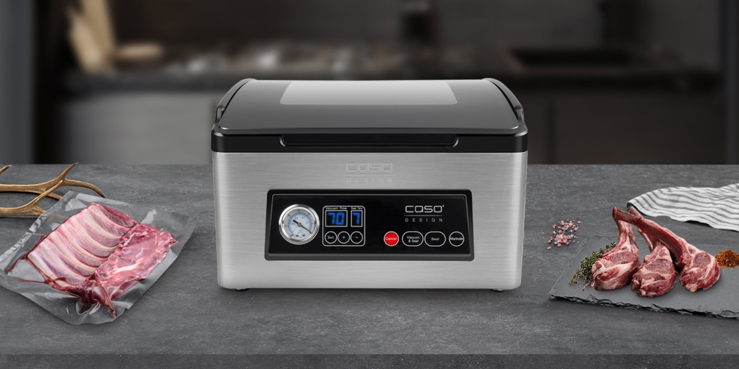 Vacuum sealer with meat and ingredients on a dark surface, ready to use.