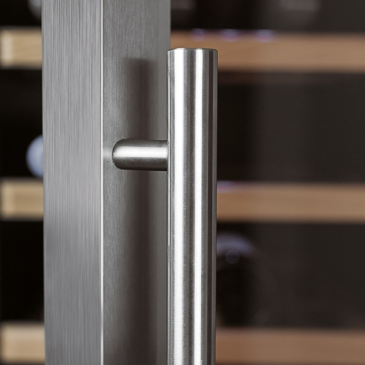 Stainless steel door handle. Vertical lines and a cylindrical handle. Close-up shot.